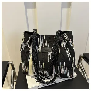 Macro della borsa tote trapuntata nera con onde colorate e patch logo in pelle