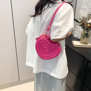 Fashion heart shaped crossbody bag in bright pink with embossed wave pattern on leather