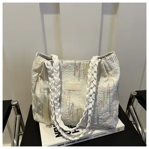 Dettaglio della borsa tote vintage con trapuntatura a rombi, ricamo arcobaleno e nappa