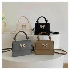 Detalle de bolsos bandolera en varios colores con hebillas de mariposa y asas de nudo