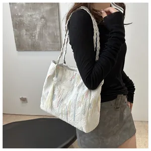 Vista dettagliata della borsa tote bianca con ricami colorati e spalline intrecciate