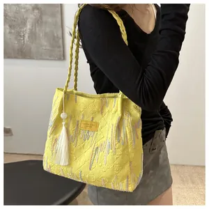 Dettaglio della borsa tote gialla con cuciture a rombi, motivo FF e ricami colorati