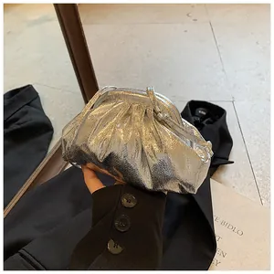 Detail view of the metallic silver pleated cloud bag with fine wrinkled texture and strap