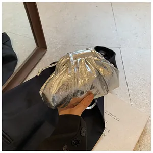 Detail of silver metallic pleated dumpling bag with a crackled texture and shoulder strap