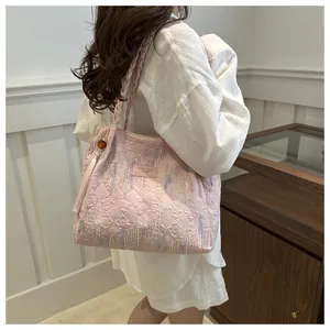 Dettaglio ravvicinato della borsa tote rosa con trapuntatura a rilievo e ricamo