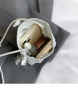 Silver bucket bag with pearl trim and tassel showing interior storage for essentials