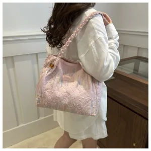 Dettaglio della borsa tote rosa con trama trapuntata e ciondolo nappa colorato