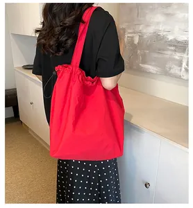 Dettaglio della borsa tote in nylon rosso con coulisse nera e trama leggera e pratica