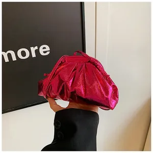 Detail of metallic fuchsia pleated handbag with glossy leather and slim handle