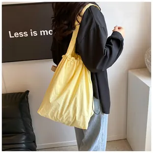 Vista dettagliata della borsa a spalla in nylon giallo pallido indossata per le dimensioni