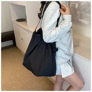 Vista dettagliata della borsa tote in nylon nero con coulisse e tracolla larga