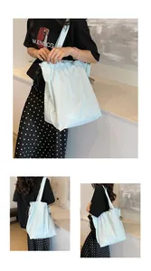 Dettaglio borsa in nylon azzurro con coulisse, bordo a balze e cordino nero regolabile