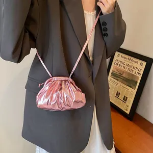 Metallic pink pleated dumpling bag for women, chic crossbody style in urban fashion setting