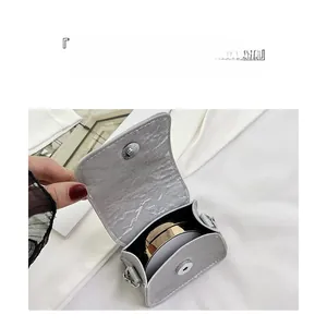 Detail of grey mini saddle bag showing magnetic clasp closure and interior storage space