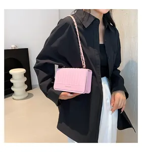 Détail du sac violet clair montrant les rayures verticales, la chaîne dorée et le logo
