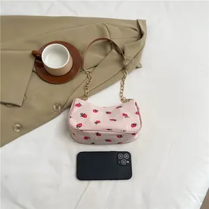 Rosa Cord-Tasche mit Erdbeermuster und goldener Kette für sommerliche Mode-Outfits