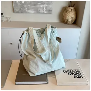 Dettaglio della borsa tote in nylon azzurro con chiusura a coulisse e texture morbida