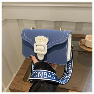 Detailaufnahme der blauen Canvas-Umhängetasche mit weißen Nähten und gewebtem Gurt