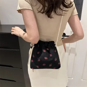 Sac seau en velours côtelé noir avec broderie fraises et bandoulière tissée