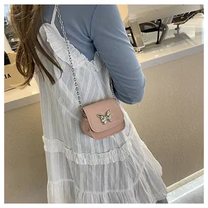 Detailed view of pink mini saddle bag with silver butterfly clasp and chain strap