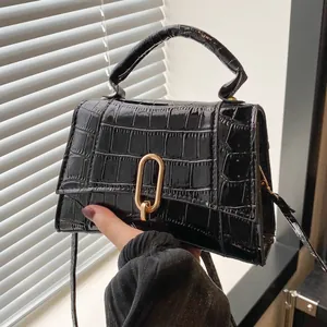 Close-up of black crocodile pattern leather texture and elegant gold oval buckle detail