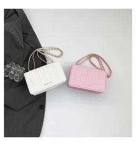 Détail des sacs à rabat matelassés blanc et rose avec chaînes dorées et texture plissée