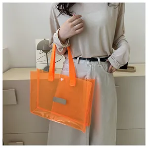 Detail of transparent orange PVC tote bag featuring woven handles and magnetic snap closure