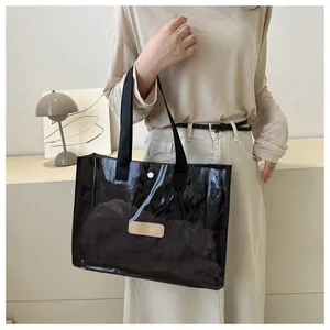 Detail of black translucent jelly tote bag with metal snap button and MS. MARISE logo