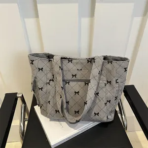 Grey corduroy tote bag with black bow lattice pattern and convenient front zipper pocket
