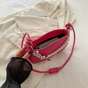 Hot pink heart-themed handbag with pearl shoulder strap and silver heart pendant detail
