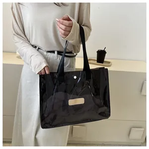 Detail view of transparent black PVC tote bag with leather patch and webbing handles