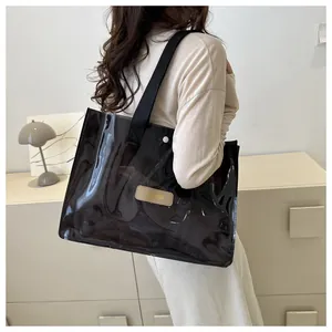 Detail of transparent black tote bag featuring MEXIUIXIBAG leather patch and fabric strap