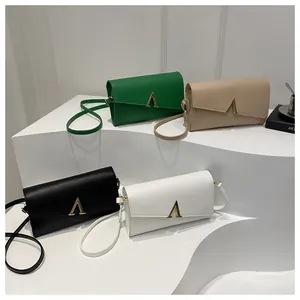 Détail de quatre sacs bandoulière enveloppe en cuir PU avec boucles en métal doré en V