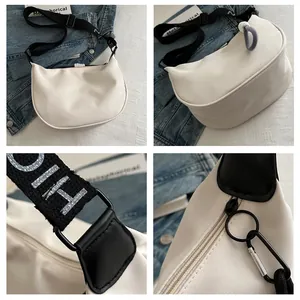 Détails du sac demi-lune blanc en toile avec bandoulière logo et fermetures métalliques