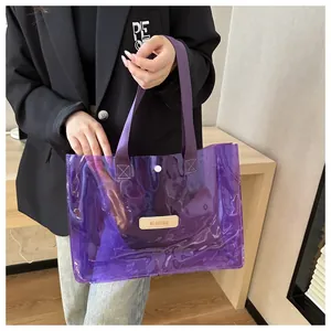 Detail of purple transparent PVC tote bag with stylish leather logo and woven handles