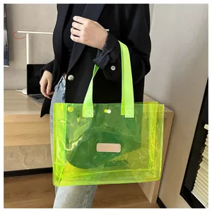 Close-up of fluorescent green transparent PVC tote bag with beige leather patch detail