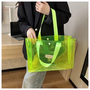 Detail of neon green transparent PVC tote bag with dual nylon straps and branded patch