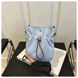 Detail van lichtblauwe nylon mini crossbodytas met geplooid ontwerp met trekkoord