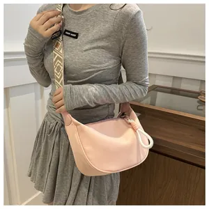 Détail du sac bandoulière demi-lune rose clair avec sangle géométrique et zip à noeud