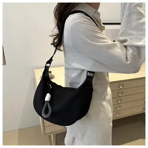 Mannequin portant un sac demi-lune noir en nylon avec un charm en corde tressée