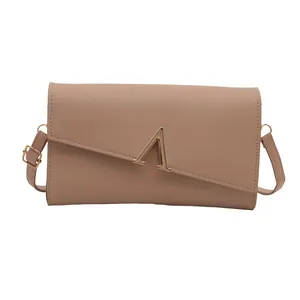 Sac bandoulière beige minimaliste avec ornement lettre A dorée et bandoulière fine