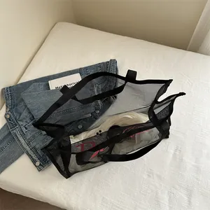 Grande borsa tote in rete nera con stampa di lettere rosa su sfondo bianco testurizzato
