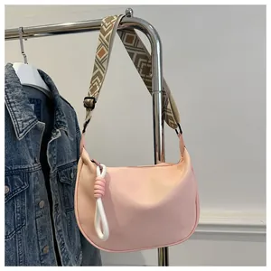 Détail de la bandoulière ethnique et du pendentif sur ce sac rose en toile robuste