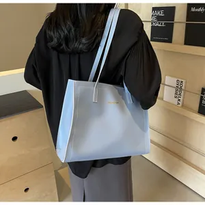 Détail du sac cabas en cuir bleu clair avec surpiqûres contrastées et logo doré