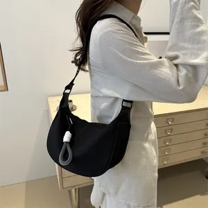 Sac bandoulière demi-lune noir minimaliste en toile avec pendentif tissé pour le quotidien
