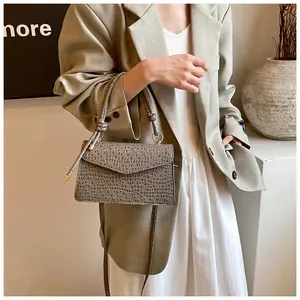Close-up of dark grey crocodile texture leather handbag with stylish knotted handle detail