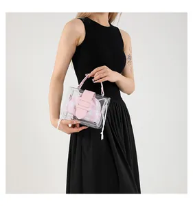 Detail van transparante PVC tas met roze leren handvat en een roze geruite binnenzakje