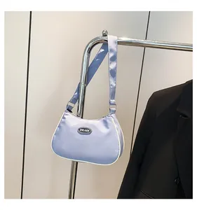 Detail of light purple nylon shoulder bag featuring white contrast trim and logo patch