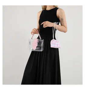 Gedetailleerde foto van transparante PVC-tas met roze handvatten en geruite binnentas