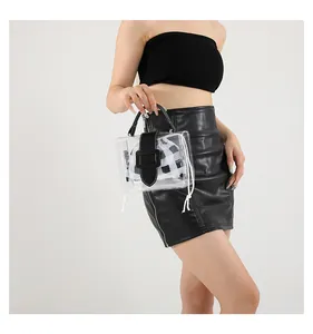 Detail van de transparante PVC-handtas met zwart leren handvat en een gingham binnentas